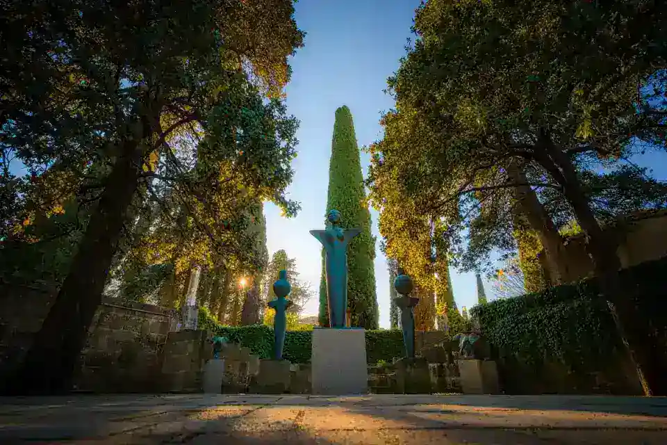 Jardin secret avec sculptures monumentales en bronze dans le quartier Salamanca de Madrid, lumière dorée à travers les arbres, atmosphère paisible